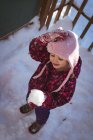 Ângulo alto de menina bonito segurando neve durante o inverno — Fotografia de Stock