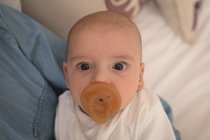 Portrait of cute little baby with pacifier in mouth looking into camera — Stock Photo
