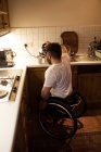 Homem com deficiência derramando café em copo em casa — Fotografia de Stock