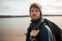 Portrait of male hiker standing with backpack at countryside — Stock Photo
