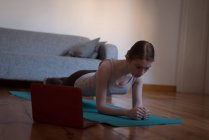 Frau übt Planken-Pose im heimischen Wohnzimmer — Stockfoto