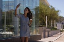 Молодая женщина делает селфи с мобильного телефона на открытом воздухе — стоковое фото