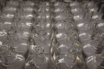 Порожні пляшки тримають поспіль на заводі — стокове фото