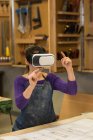 Falegname femminile utilizzando cuffie realtà virtuale in officina — Foto stock