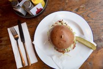 Vue du dessus du hamburger servi dans une assiette au restaurant avec couverts . — Photo de stock