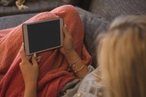 Frau nutzt digitales Tablet im heimischen Wohnzimmer — Stockfoto