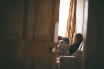 Frau liest im Wohnzimmer ein Buch — Stockfoto