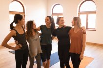 Gruppo di donne in piedi insieme con braccio intorno nel fitness club — Foto stock