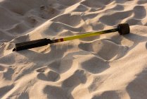 Primer plano del palo levi fuego en la arena de la playa a la luz del sol - foto de stock