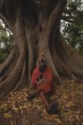 Porträt eines Massai-Mannes, der sich unter einem Baum entspannt — Stockfoto