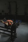 Інвалідний чоловік робить барбелл-лавку, натискаючи під час тренувань у фітнес-клубі — стокове фото