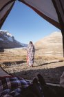 Rückansicht einer in eine Decke gehüllten Frau an einem sonnigen Tag — Stockfoto
