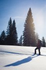 Woman walking on snowy slope on a sunny day — Stock Photo