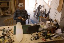 Mann bastelt Skateboard in Werkstatt, über Kopf — Stockfoto