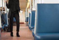 Низька частина жінки, яка має каву під час подорожі в поїзді — стокове фото