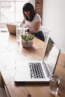 Executivo feminino usando laptop no escritório criativo — Fotografia de Stock