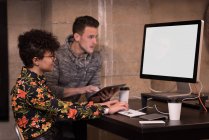 Чоловіки і жінки-керівники, що працюють на комп'ютері за столом в офісі . — стокове фото