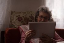 Aktive Seniorin nutzt digitales Tablet zu Hause — Stockfoto
