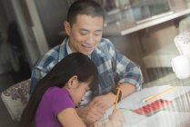 Padre che aiuta sua figlia a fare i compiti a casa — Foto stock
