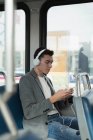 Homem ouvindo música no fone de ouvido enquanto viaja em ônibus — Fotografia de Stock