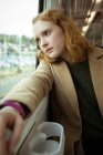 Крупним планом червоне волосся молода жінка дивиться зовні з вікна поїзда — стокове фото