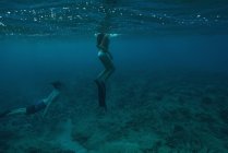 Pareja buceando bajo el agua en mar turquesa - foto de stock