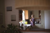 Nachdenkliche reife Frau beim Kaffee in der Küche zu Hause — Stockfoto