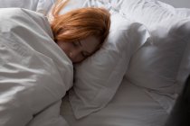 Mujer durmiendo en el dormitorio en casa - foto de stock