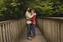Coppia affettuosa in piedi sul ponte pedonale — Foto stock