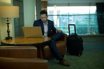 Uomo d'affari che utilizza il computer portatile in hotel — Foto stock