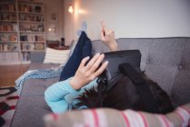 Donna che utilizza auricolare realtà virtuale in soggiorno a casa — Foto stock