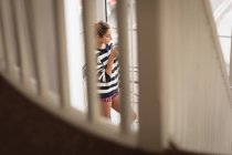 Mulher tomando café perto da janela em casa — Fotografia de Stock
