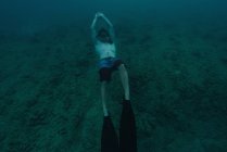 Человек ныряет с маской под водой в морской воде — стоковое фото