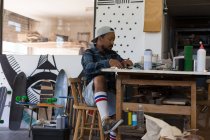 Homme faisant du design sur papier dans un atelier de skateboard — Photo de stock