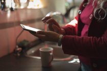 Mittlerer Abschnitt der reifen Frau mit digitalem Tablet in der Küche — Stockfoto