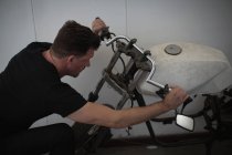 Mechaniker überprüft Motorrad in Garage — Stockfoto