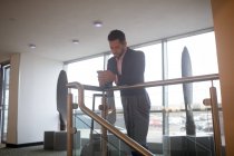 Empresário usando telefone celular no corredor do hotel — Fotografia de Stock