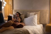 Paar nutzt digitales Tablet zu Hause im Schlafzimmer — Stockfoto