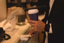 Partie médiane de l'homme d'affaires effectuant le paiement NFC dans le café — Photo de stock