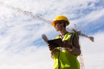 Female architect using digital tablet at construction site — Stock Photo