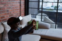 Homem sênior usando fone de ouvido de realidade virtual em casa — Fotografia de Stock