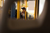 Jovem empresário pega celular enquanto viaja de ônibus — Fotografia de Stock