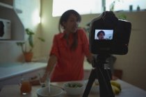 Жіночий відео блогер записує відеоблог на кухні вдома — стокове фото