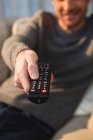 Close-up of man changing channel with remote control at home — Stock Photo