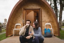 Casal afetuoso tomando café fora da cabine de log — Fotografia de Stock