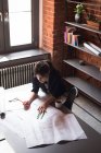 Женщина-руководитель работает над чертежом в офисе — стоковое фото