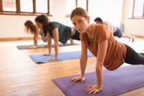 Groupe de personnes effectuant des exercices de yoga ensemble dans un club de fitness — Photo de stock