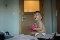 Дитячий хлопчик посміхається на ліжку вдома — стокове фото