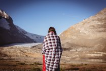Rear view of woman wrapped up in blanket on a sunny day — Stock Photo