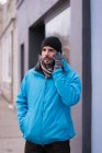 Мужчина разговаривает по мобильному телефону на городской улице зимой . — стоковое фото